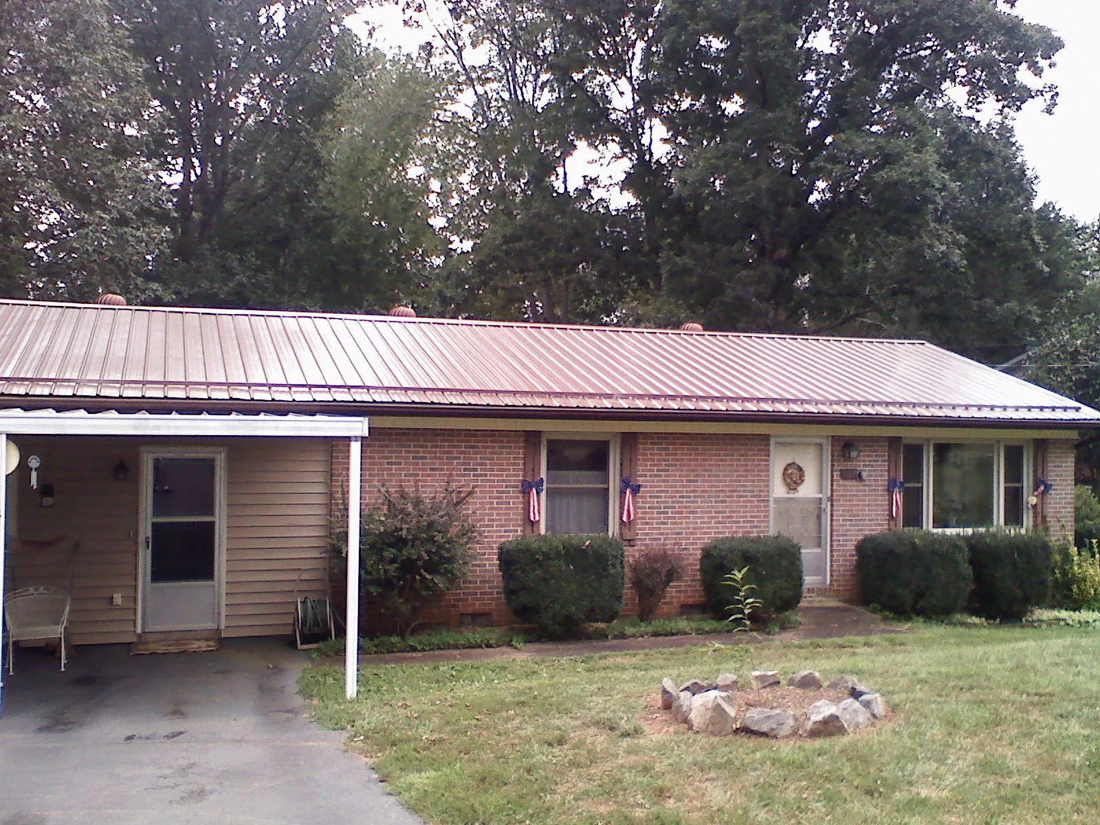 Bronze metal roof and carport on a brick ranch home — Roof Repair work by our crew in Courtenay